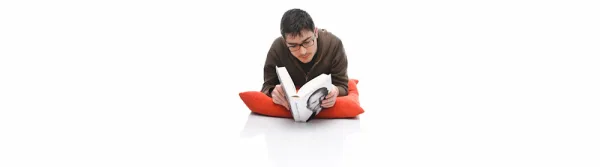 Man reading a Steve Jobs biography, on a white seamless background