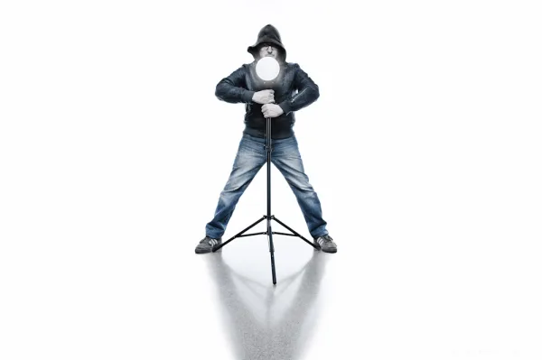 Man holding a light stand on a white seamless background, with a bluish look