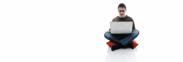 Man using a laptop on a white seamless background